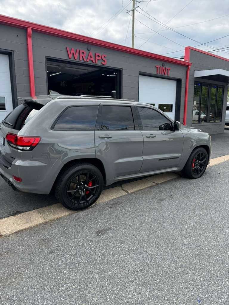 Gray Jeep Grand Cherokee SRT with tinted windows outside the Wraps and Tint bays